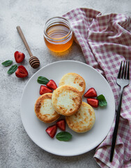 Cottage cheese pancakes, ricotta fritters on ceramic plate with  fresh strawberry.