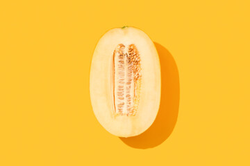 Melon half on yellow background. Flat lay, top view, copy space