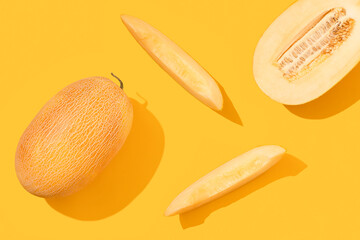 Melon cut into pieces on a yellow background.