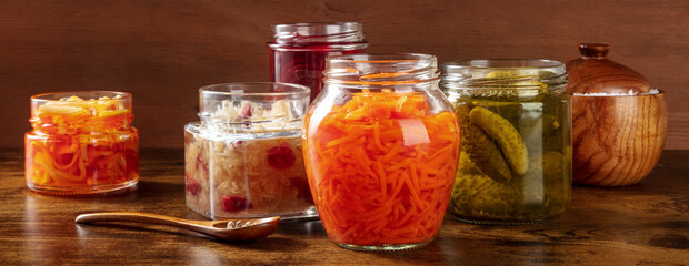 Fermented, probiotic food rustic panorama. Canned vegetables. Pickled carrot, sauerkraut, gherkins...
