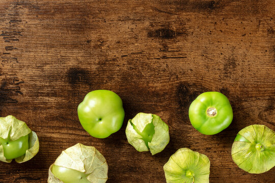 Tomatillos, Green Tomatoes, Top Shot With Copy Space. Mexican Food Ingredient On A Dark Rustic Wooden Background