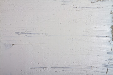 The background is made of a wall plastered with white putty with irregularities, smudges and scratches on the plaster