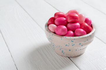 Colorful gum in a bowl on a white wooden background. Holiday concept, baby treats.