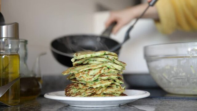 Cooking at home. Frying of appetizing vegetarian zucchini fritters