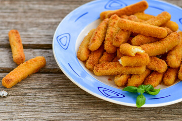 
 Crispy  deep fried     turkey nuggets and ketchup. Breaded  turky efillets  with chilly peppers and fresh basi on wooden rustic background