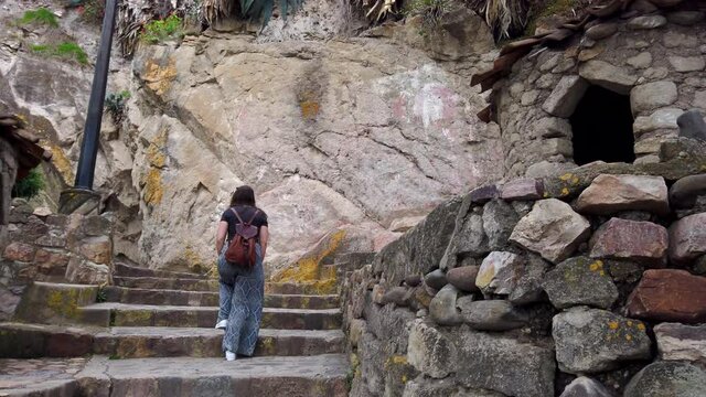 Back View Of A Female Tourist With Backpack Climbing Up A Stone Stairway At Cerro Santa Apolonia In Cajamarca, Peru. - Pan Right Shot