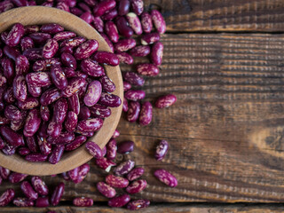 red beans with a pattern. (Delicious variegated, raw common beans) in a wooden bowl on an old wooden table, legumes. Copy space