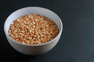 Yellow peas in a bowl. Black background