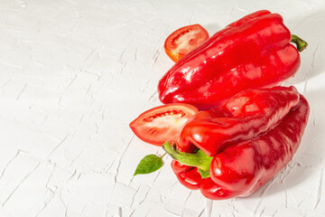 Giant red bell peppers and tomatoes on white background