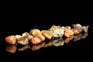 Lot of whole natural colorful rocks isolated on black glass