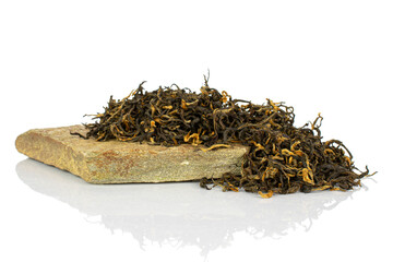 Dry black tea leaves on flat rock isolated on white background