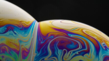 Soap bubble macro rainbow colors creating multicolored patterns. Colorful foam soap bubble slow motion. Very similar to other galaxy planets. Close up.