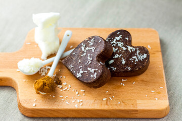 on the table there are handmade chocolates made of coconut oil, coconut chips and cocoa. dessert according to the recipe of proper nutrition.