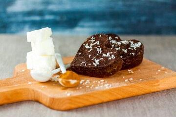 on the table there are handmade chocolates made of coconut oil, coconut chips and cocoa. dessert according to the recipe of proper nutrition.