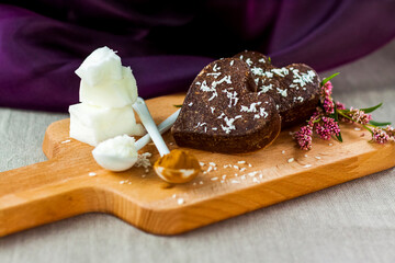 on the table there are handmade chocolates made of coconut oil, coconut chips and cocoa. dessert according to the recipe of proper nutrition.
