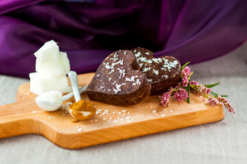 on the table there are handmade chocolates made of coconut oil, coconut chips and cocoa. dessert according to the recipe of proper nutrition.