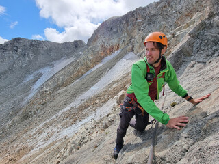 Via Ferrata mountain hike climber man climbing on steep rock in Whistler, BC, Canada travel...