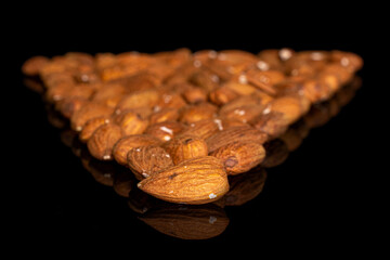 Lot of whole almond placed in triangle shape on black glass