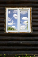 The sky in the window against the background of a log house