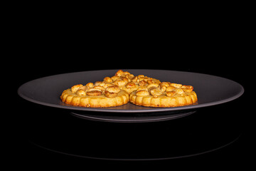 Group of three whole delicious cookie with peanuts on gray ceramic plate on black glass