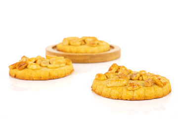 Group of three whole delicious cookie with peanuts on bamboo coaster on white background