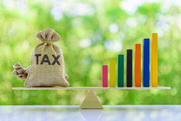 Growth in income tax collection, tax payer increasing concept : Tax bags, rising bar graph on a...