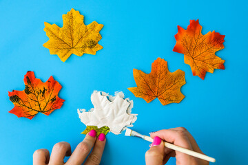 Maple leaf with painted face as decoration for autumn Halloween holiday celebration. Halloween...