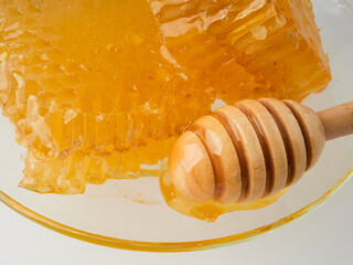 Glass pot of honey, honeycombs and sweet sticky honey puddle isolated on white background.