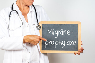 Eine Ärztin zeigt auf eine Tafel auf der Migräne Prophylaxe steht