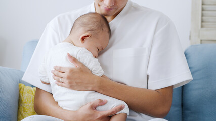 Obraz na płótnie Canvas 赤ちゃんを抱っこするイクメンなパパ（家族・ファミリー・育児・子育て）