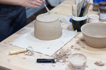 Fototapeta na wymiar craftsman makes a clay pot in a workshop