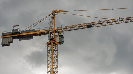 Fragment of a working tower crane at a construction site.
