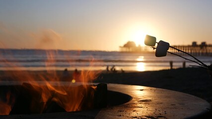 Campfire pit by Oceanside pier, California USA. Camp fire on ocean beach, bonfire flame in cement...