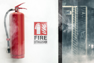 Fire Extinguisher on a white wall, with extinguisher sign in a room with smooke. - obrazy, fototapety, plakaty