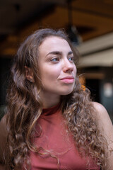 Smiling european young woman with dark curly hair portrait