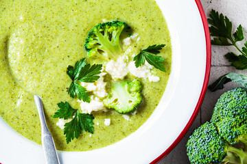 Broccoli soup puree with feta cheese in plate, close-up. Cooking healthy food concept.