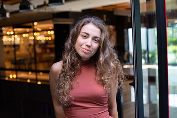 European young girl with dark and curly hair with lights behind