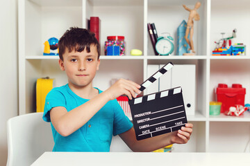 School boy holding black film making clapperboard. Producer making film. New idea for school project.