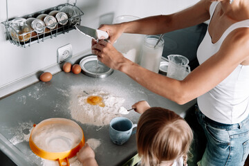 Top view table with hands of  mother and little daughter preparing dough for ginger cookies on kitchen. Happy family, cozy apartments.
