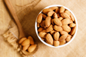 Almonds in a  bowl on wooden table