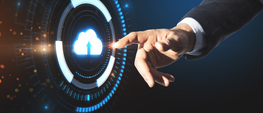 Close up of businessman hand pointing at creative glowing blue clouds hologram on dark background. Cloud computing and database concept.