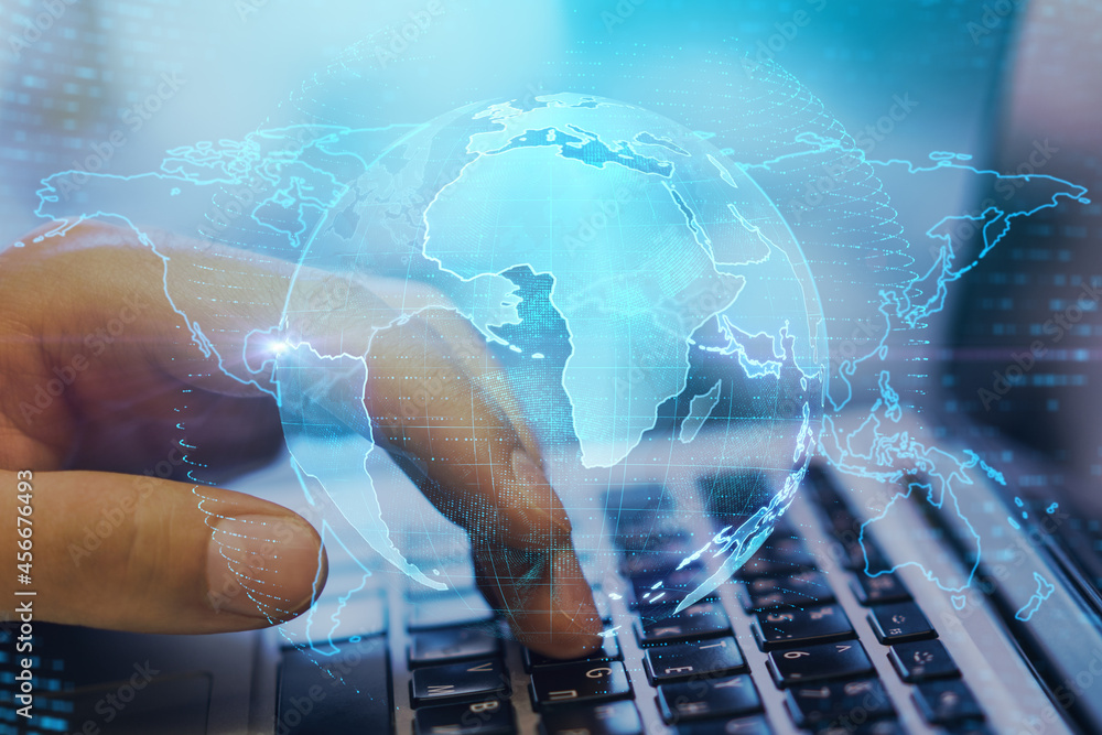 Aufkleber Close up of hands at desktop using laptop computer with creative glowing globe interface on dark background. Technology, network and online data concept. Double exposure.