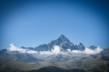 Fototapeta premium the peak of the monviso shrouded in clouds on a splendid August day. near crissolo, in piedmont