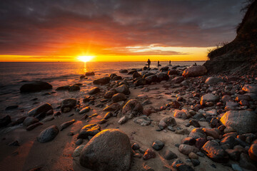 Anglers standing on the rock in Baltic Sea at sunrise, Gdynia. Poland