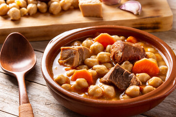 Traditional Spanish cocido madrileño on wooden table. Chickpea stew.