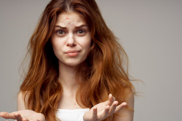 beautiful woman in a white t-shirt pimples on the face light background