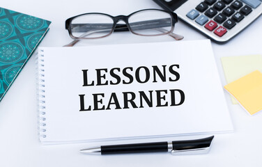 Lessons learned text concept write on notepad on office desk