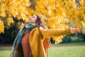 Carefree woman feeling free in beautiful autumn colors