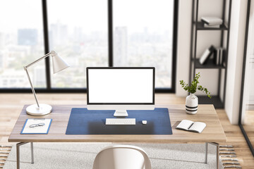 Close up of empty white computer screen in creative modern daylight office studio interior with glass partition and window with city view, wooden flooring. 