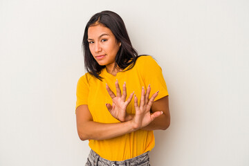 Young latin woman isolated on white background  doing a denial gesture